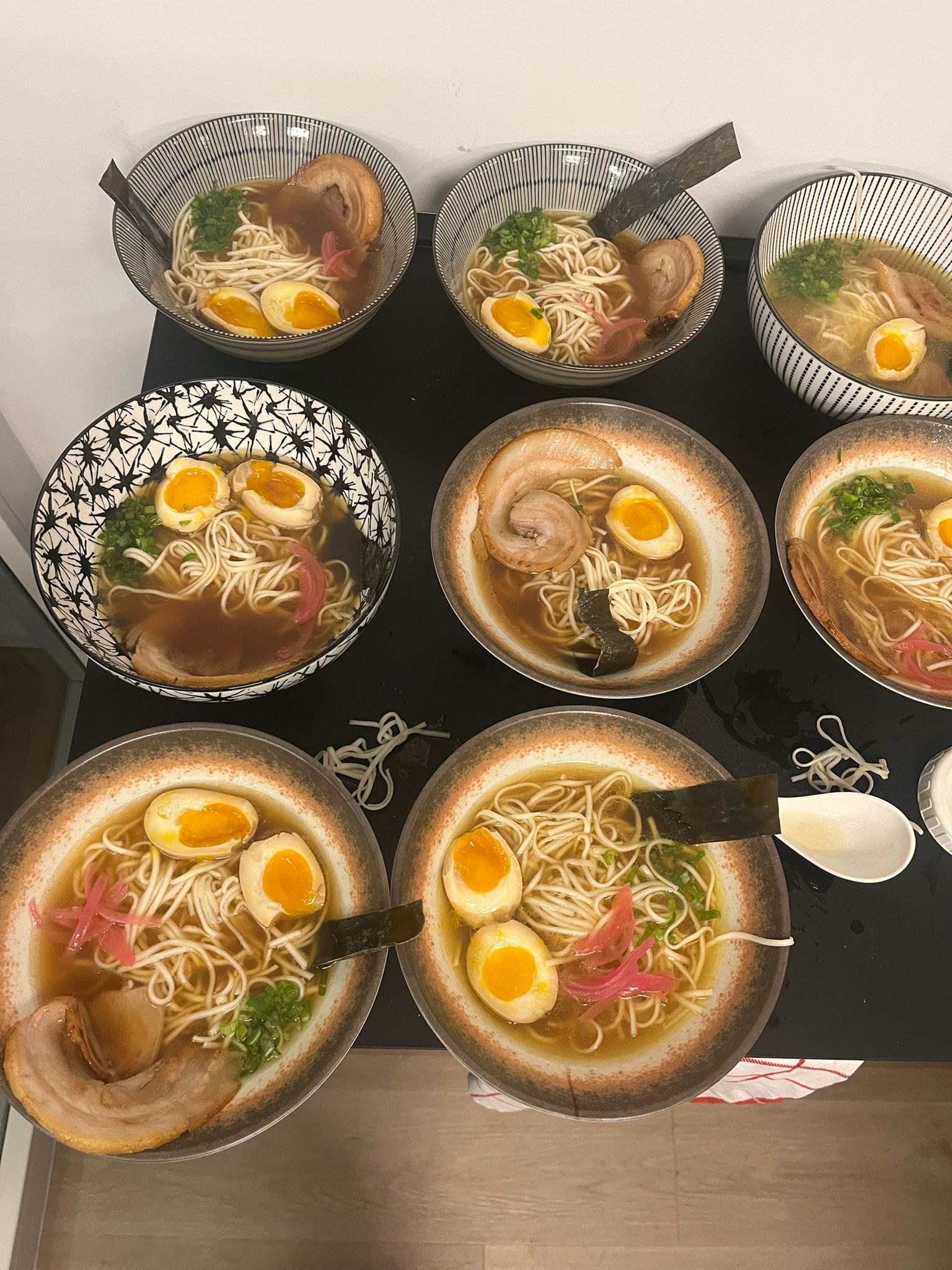 Nine bowls of homemade double-soup shoyu ramen prepared for friends